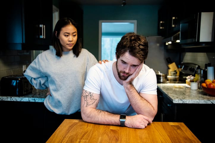 woman with hand on man's shoulder