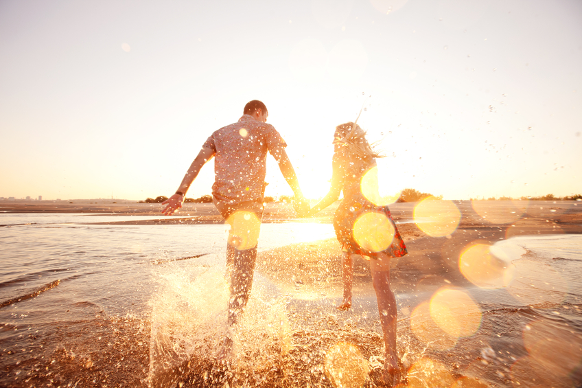 couple running beach sunshine