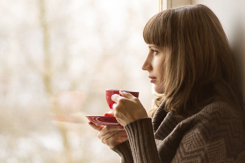 Beautiful girl drinking Coffee or Tea near Window