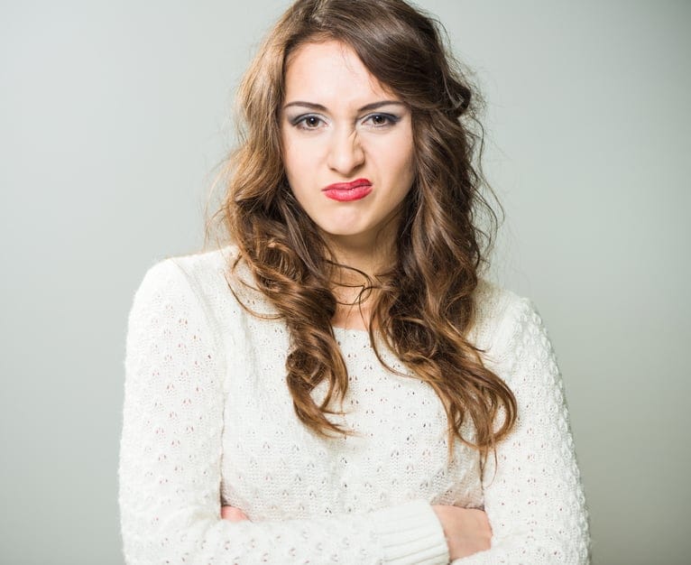 young caucasian brunet woman portrait with disgust face expression