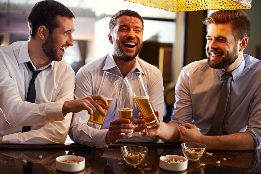 Three joyful men toasting with beer