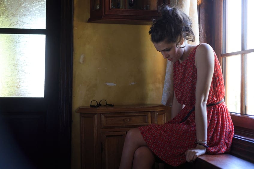 Sad woman sitting on the window