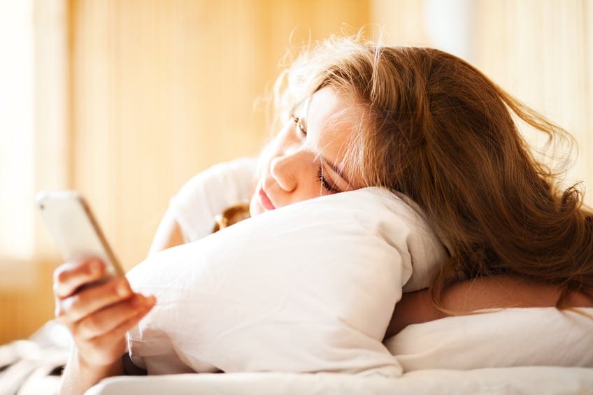 woman texting bed morning
