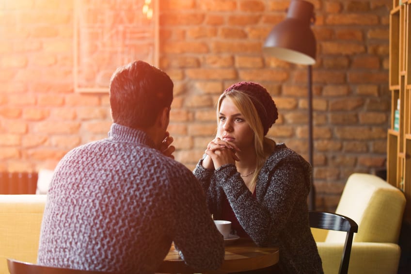Young couple having serious conversation in coffee shop.