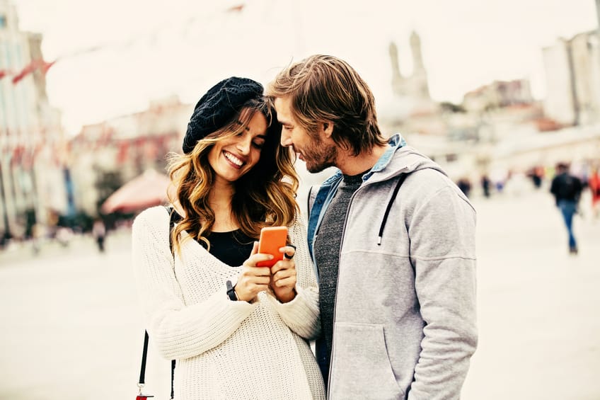 Happy young couple texting