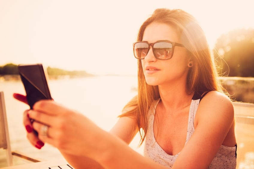 woman serious texting sun