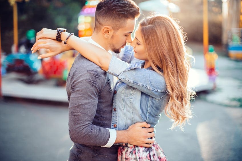 Young couple embracing in luna park.