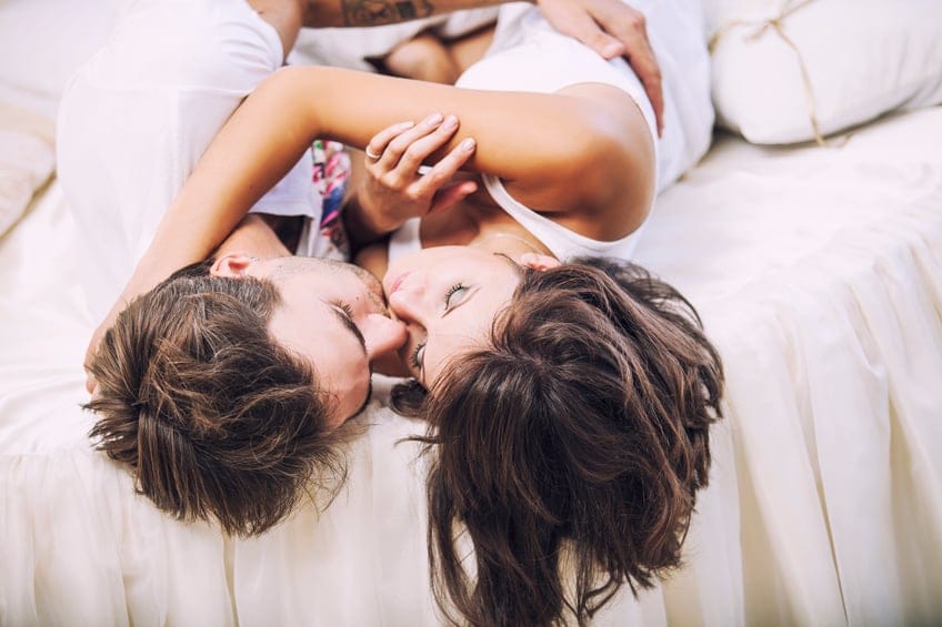 Couple man and woman lay cuddling on the bed