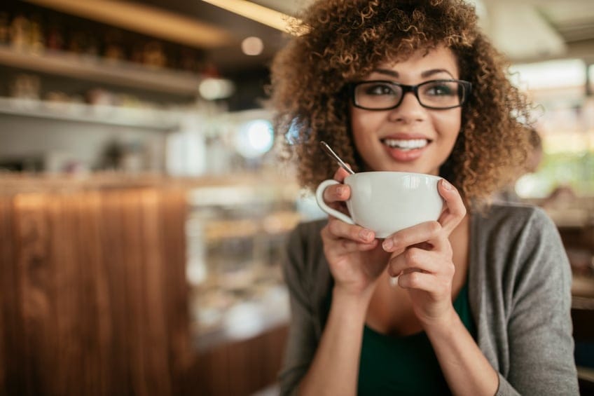 Photo of a young woman enjoying morning coffee in cafe