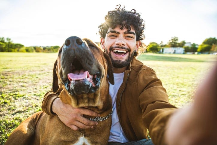 Guy taking selfie with dog.