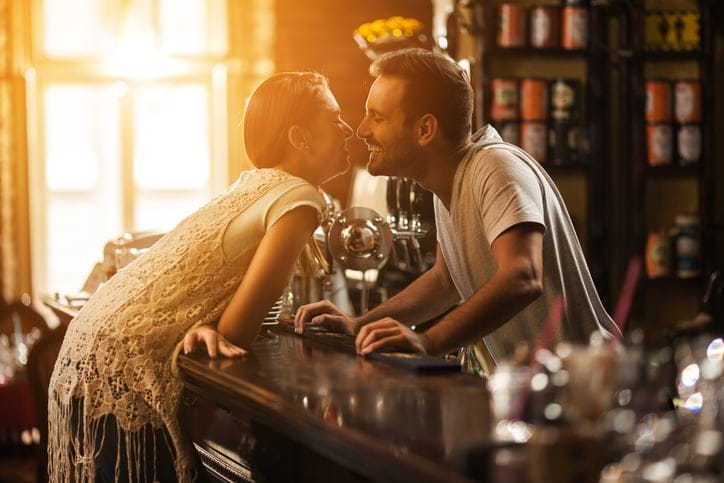 couple kissing bar romance love