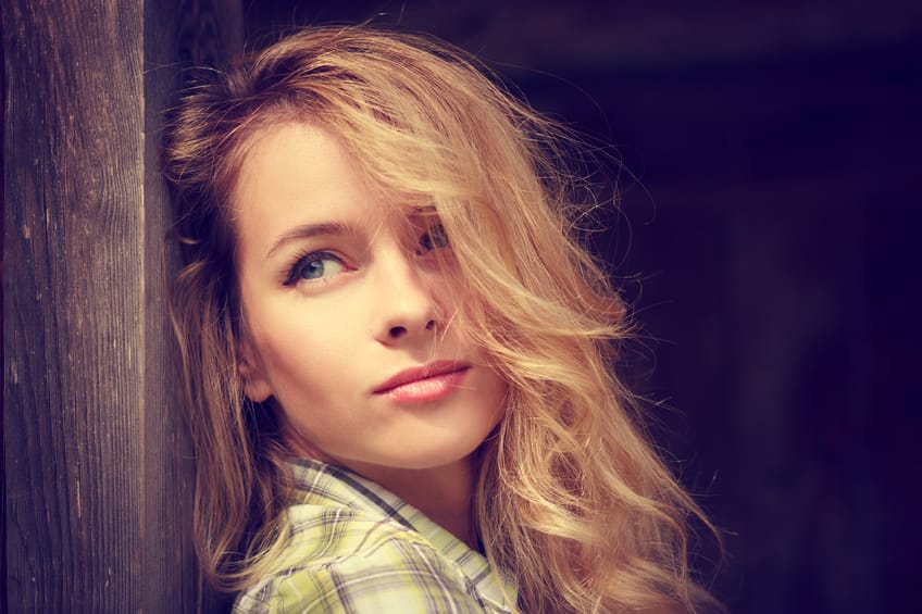 Portrait of a Dreamy Hipster Girl on Wooden Background. Romantic Woman. Toned Photo with Copy Space.