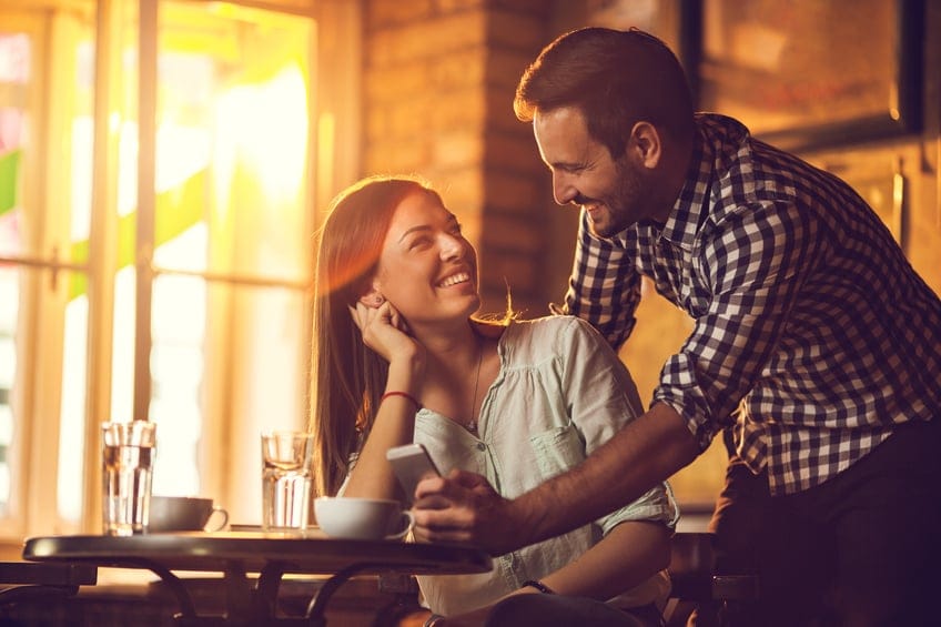 Loving young couple looking at each other and talking in a cafe.
