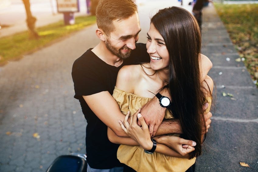 Beautiful young couple relaxing in the park and makes selfie