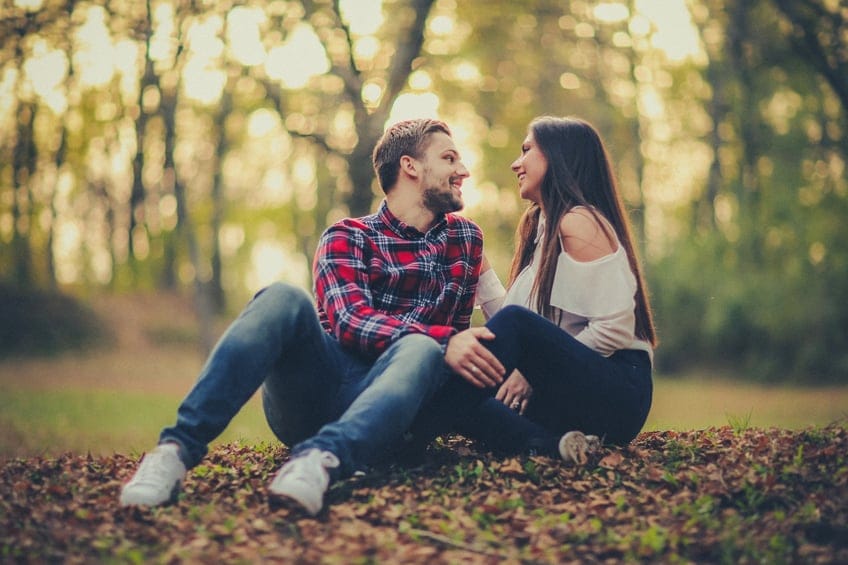 Couple sat outside leaves