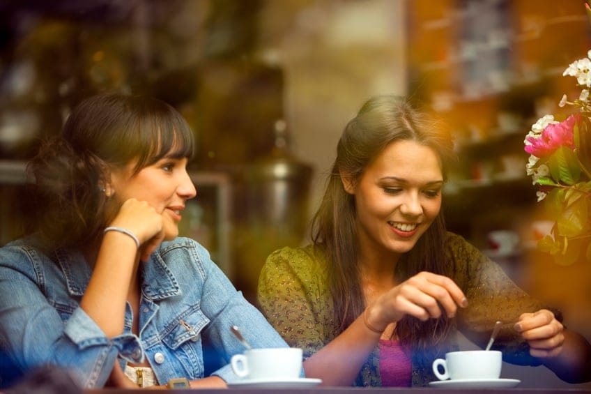 Two Young Beautiful Women Sitting in a Cafe