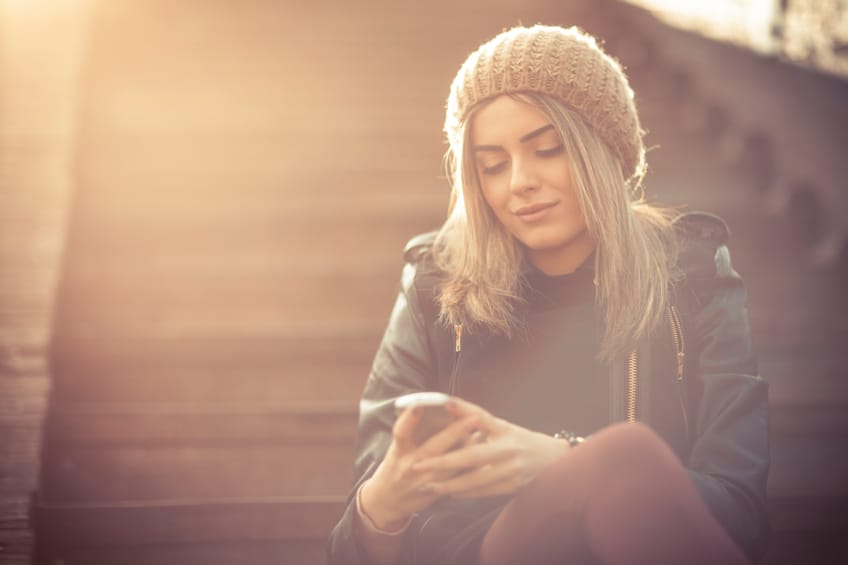 young woman texting outdoors autumn