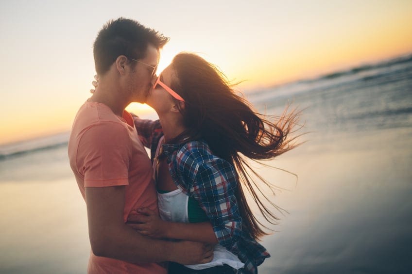Couple kissing at sunset on beach