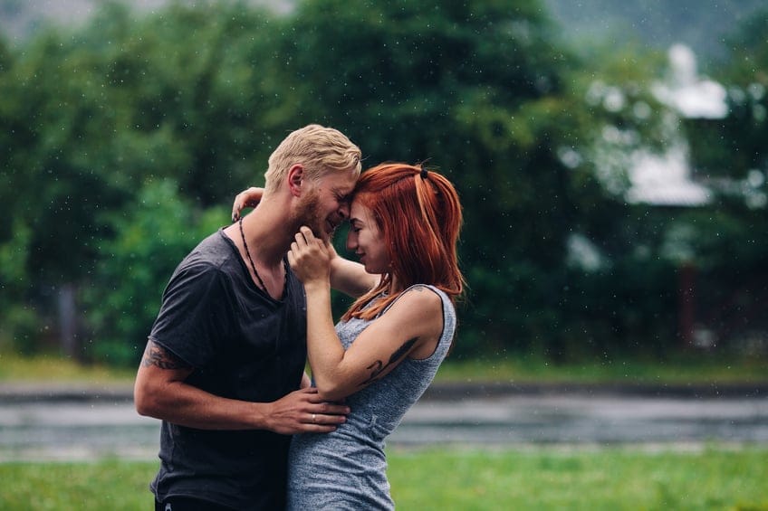 beautiful couple hugging on outside in the rain