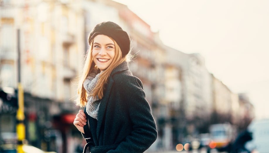 Happy woman walking dawn the street.