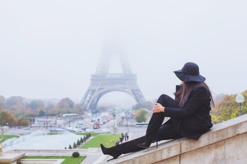Woman looking at Eiffel Tower on a foggy day in Paris, France.