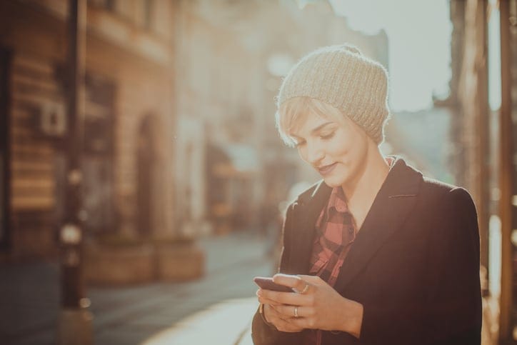 young woman hipster texting phone sun