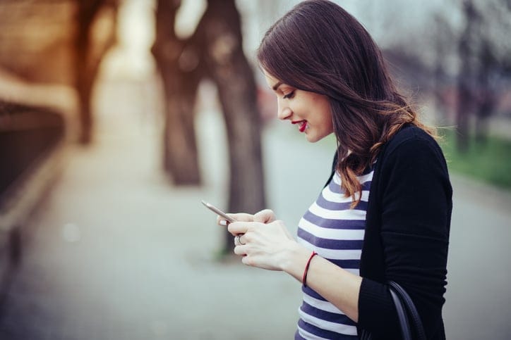 young woman texting outdoors