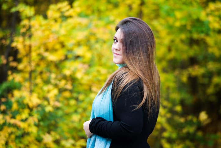 Young beautiful caucasian plus size model in black dress outdoors, xxl woman on nature, autumn atmosphere, plump women
