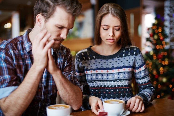 Young couple relaxing in cafe by cup of cappuccino