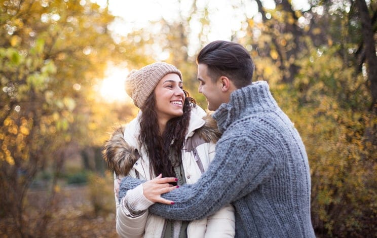 Smiling couple hugging in park