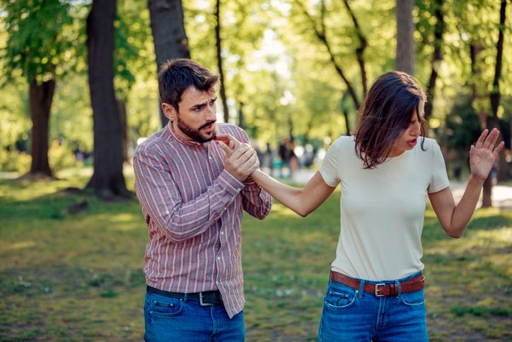 young couple arguing in park