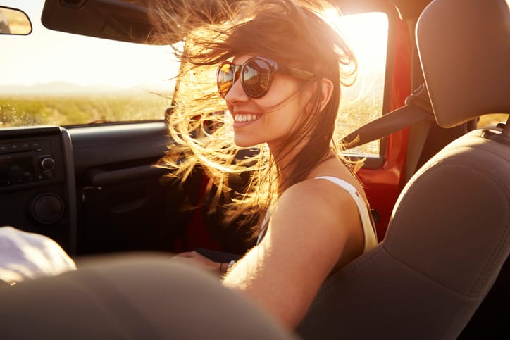 young woman car sunshine road trip