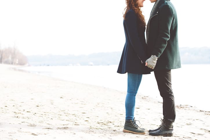 young couple beach holding hands romance