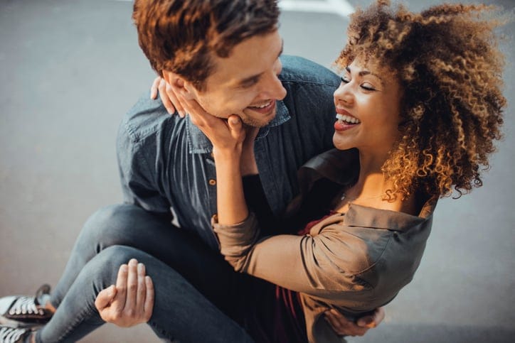 Close up of a young man carrying his girlfriend