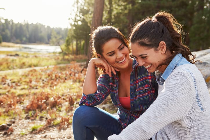 Happy friends laughing together in the countryside