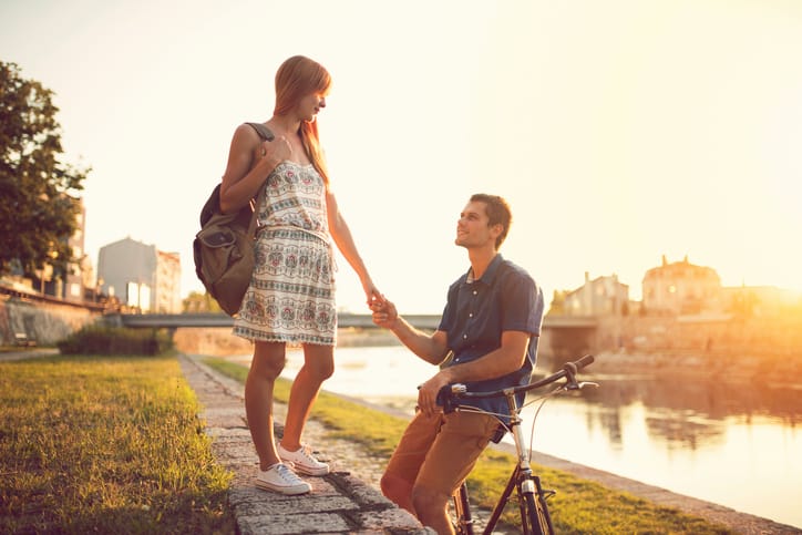 Beautiful love couple enjoying a romantic summer day by the river.