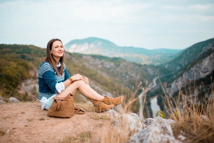 Hippie girl sitting in the mountains.