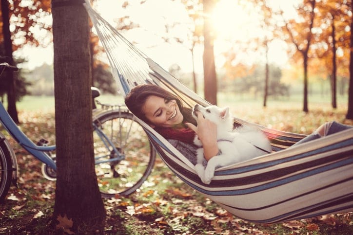 young woman dog happy hammock outdoors