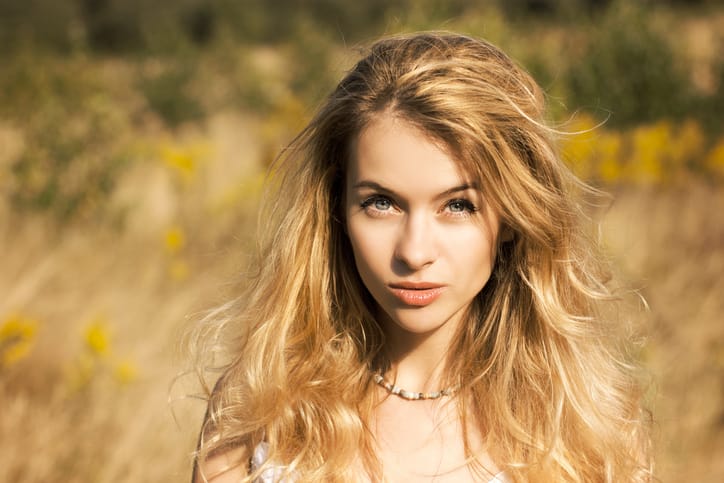 Portrait of Beautiful Blonde Woman at Summer Field