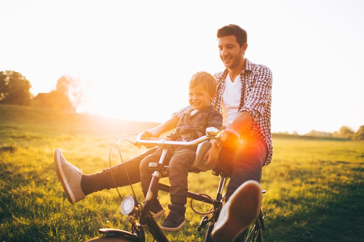 Father and his son cycling together outdoors