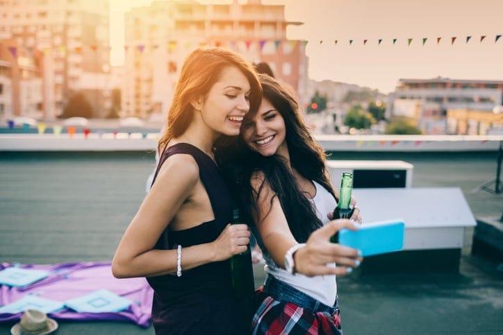 Two girls taking selfie on the rooftop.