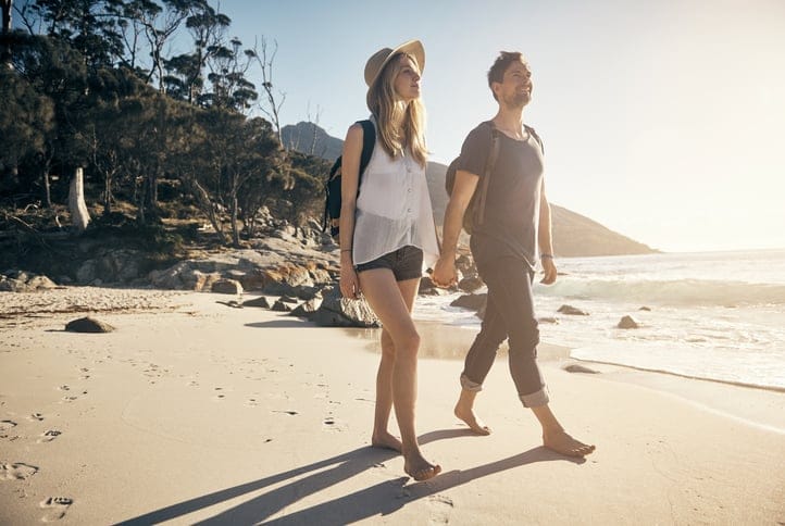 Shot of a young couple going for a stroll along the beach