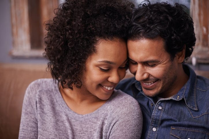 A happy young couple smiling while sitting together