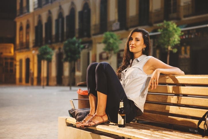 oung tourist woman relaxing downtown in the evening, having a lager beer.