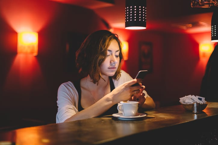 Girl using smartphone in a cafe