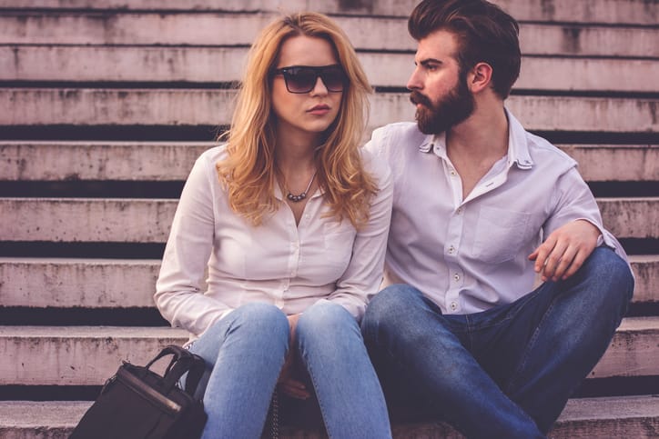 Beautiful business couple sitting on stairs and discuss about job