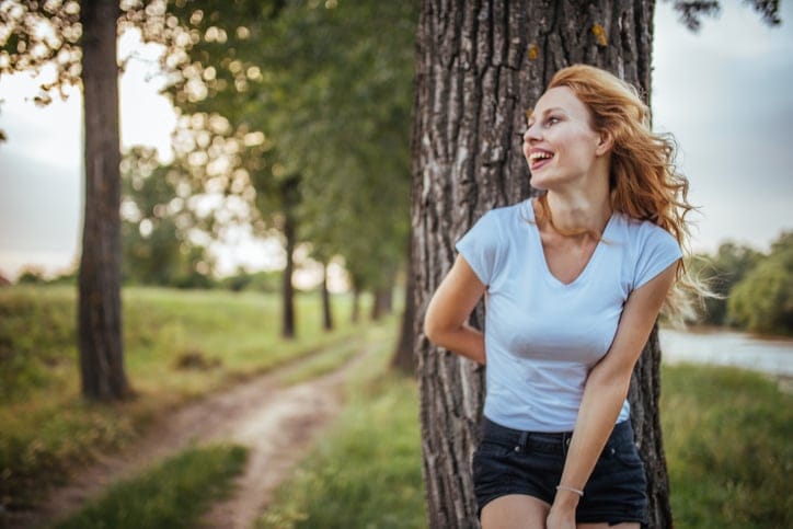 Young curly haired blonde woman enjoying the leisure time outdoors on a hot summer day.
