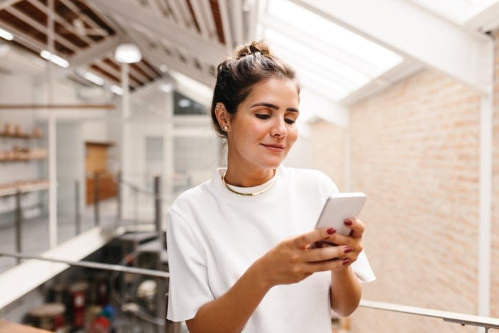 Smiling woman texting.