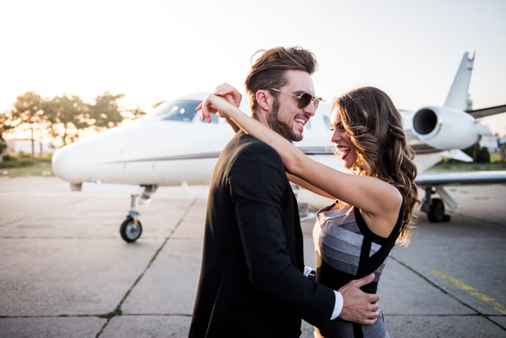 Young famous couple hugging at the airport