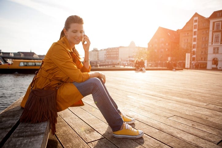 Woman sitting on a bench near canal of Copenhagen.